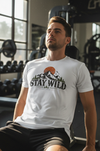 Man resting on a gym bench in a white Stay Wild printed sports jersey t-shirt
